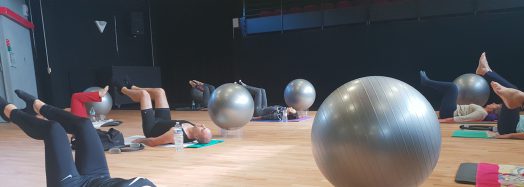 Cours de Pilates : participantes allongées sur des tapis avec des ballons